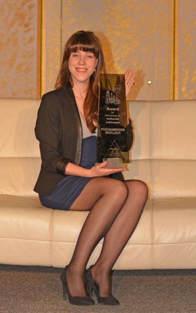 Sabrina Kotlan hält den Award für herausragende kulturelle Leistungen in den Händen